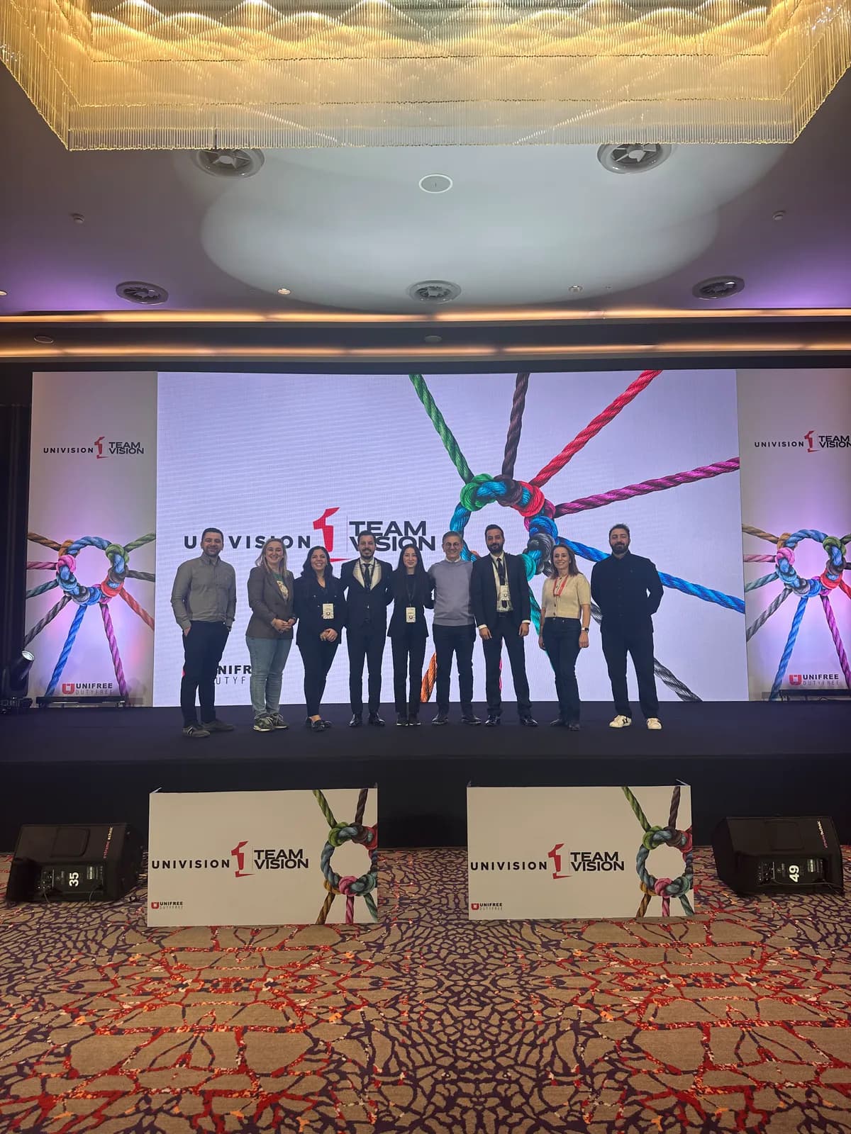 the whole team together in front of the stage