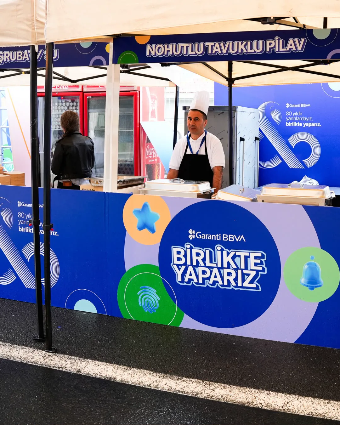 Yemek noktası: markalı stantta servis yapan aşçı
