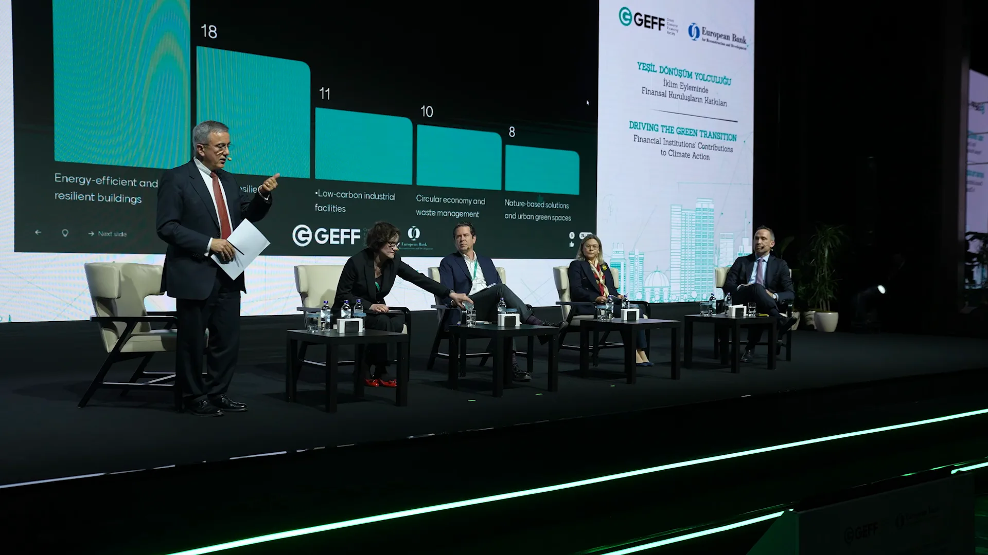 Panel oturumu: sahnede konuşmacılar, önlerinde dolu salon