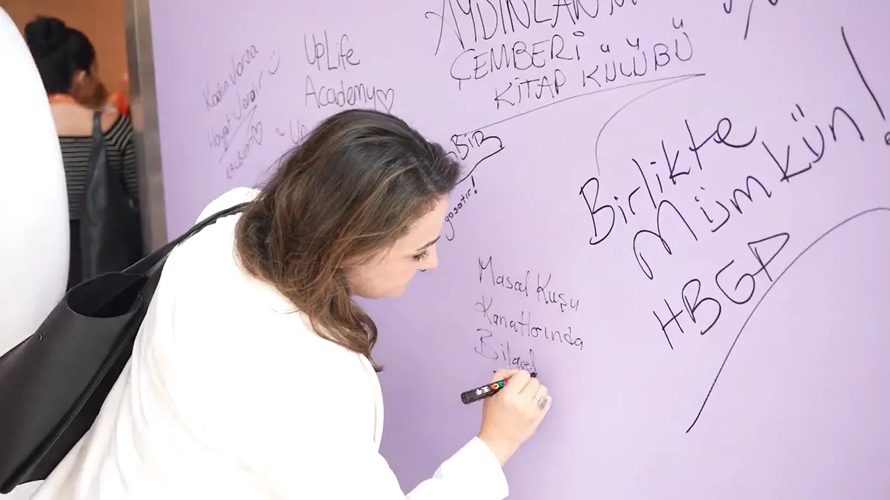 Dilek duvarına not yazan katılımcı